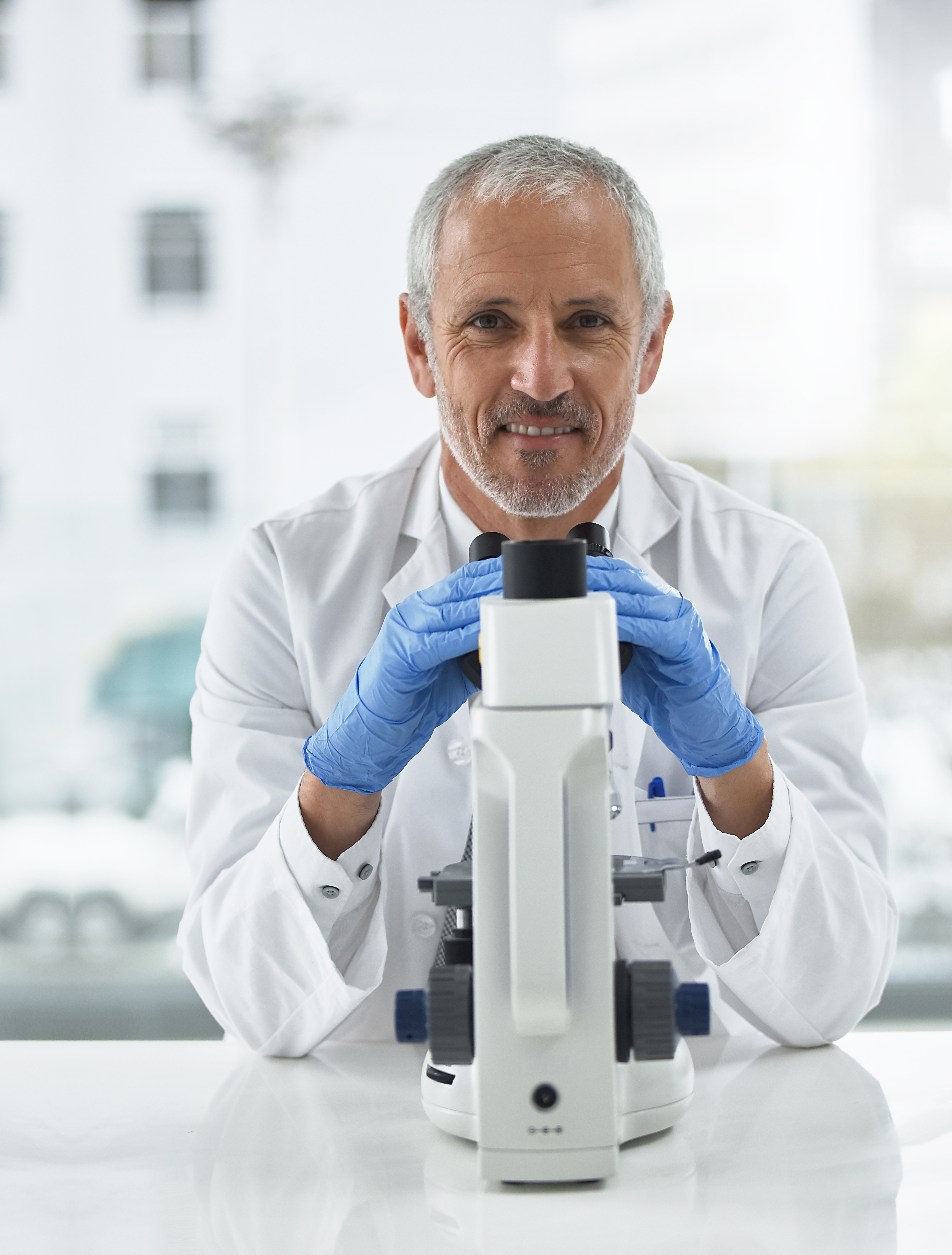 Portrait of a researcher at work on a microscope in a lab